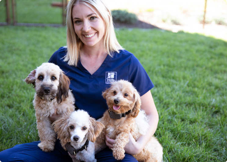 A Hill's munkatársa három kölyköt tart az ölében